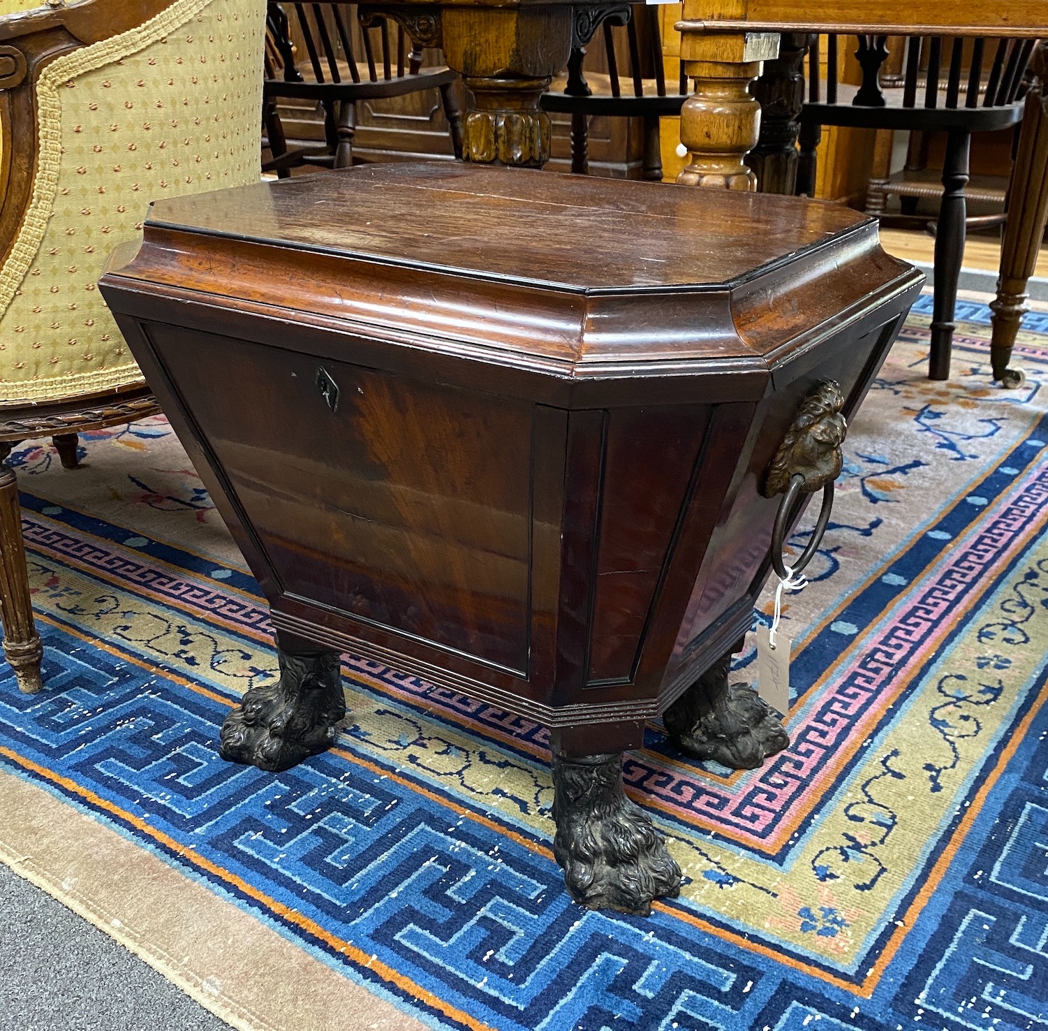 A Regency and later mahogany sarcophagus wine cooler on cast metal lions paw feet, width 56cm, depth 45cm, height 50cm.